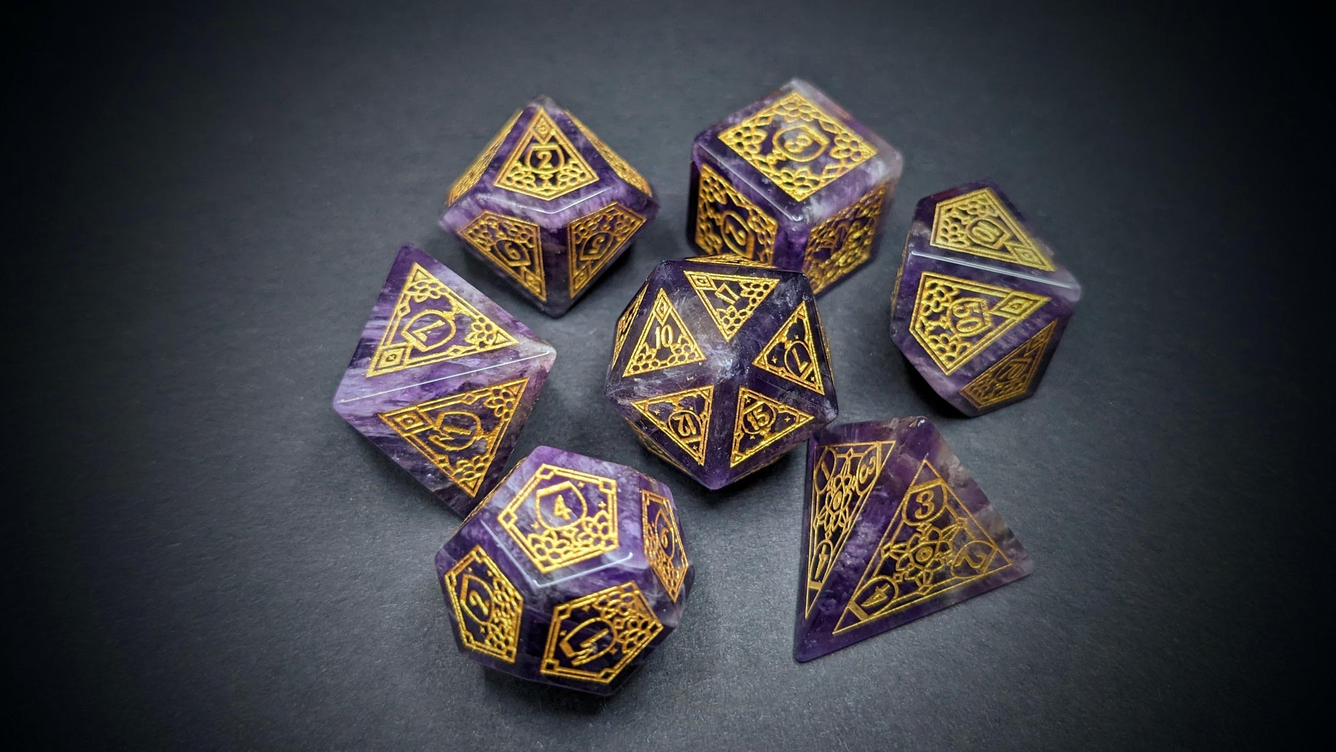 a rich amethyst gemstone set of dice with lovely variations in the stone that provide brighter bits of contrast to the deep purple.